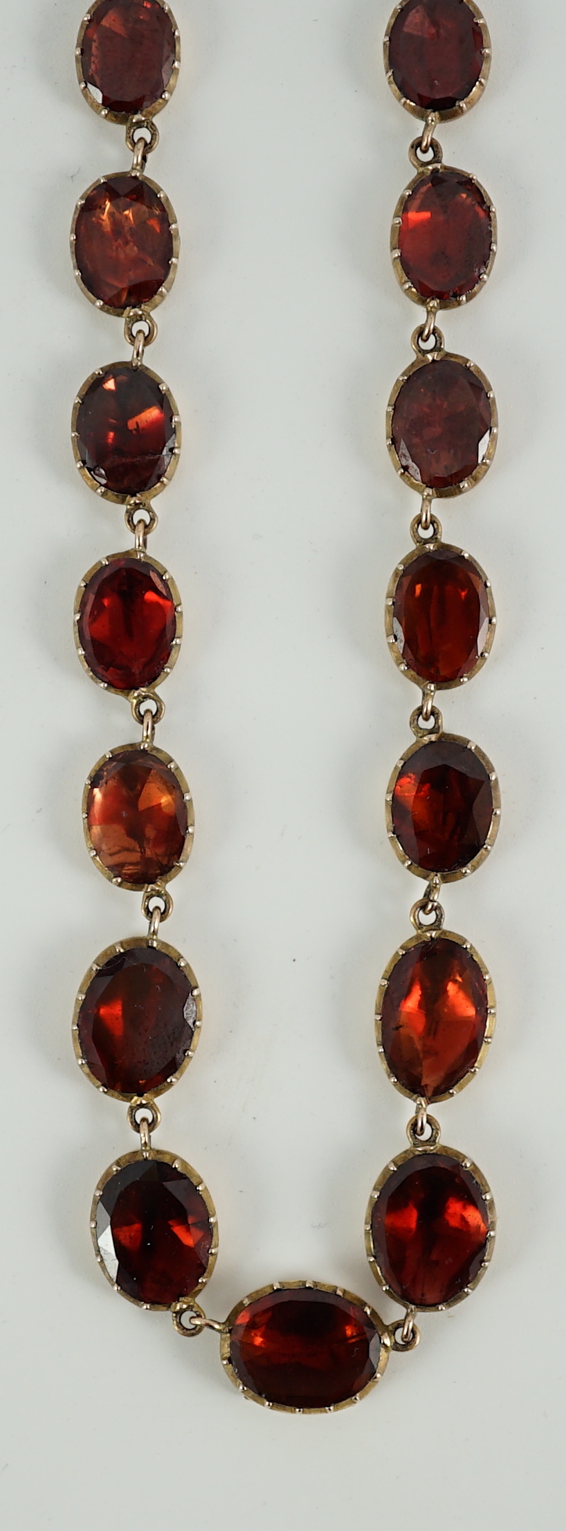 An early 19th century gold mounted graduated foil backed oval cut garnet set choker necklace